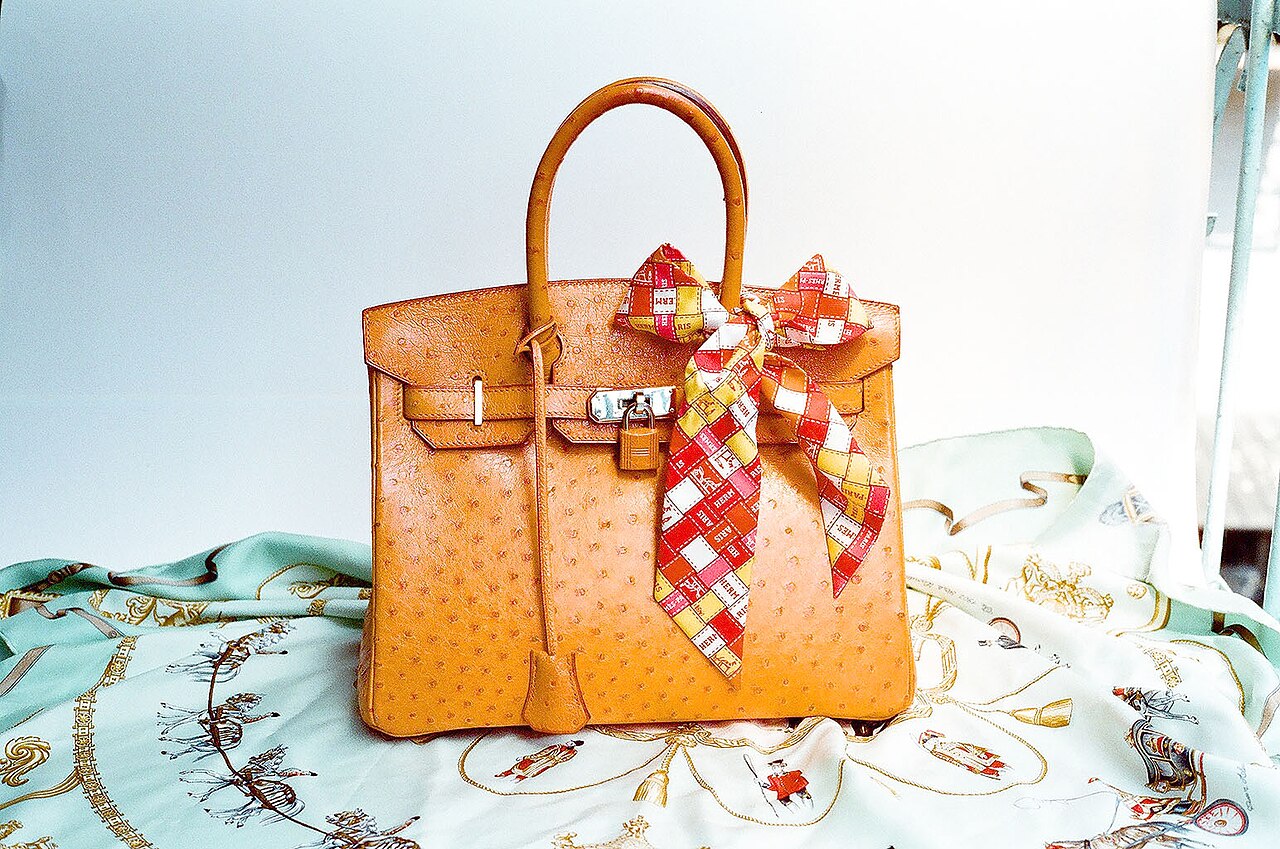 Cognac ostrich Hermès Birkin with a silk scarf, photographed by Wen-Cheng Liu. Licensed photograph, not an official campaign image.